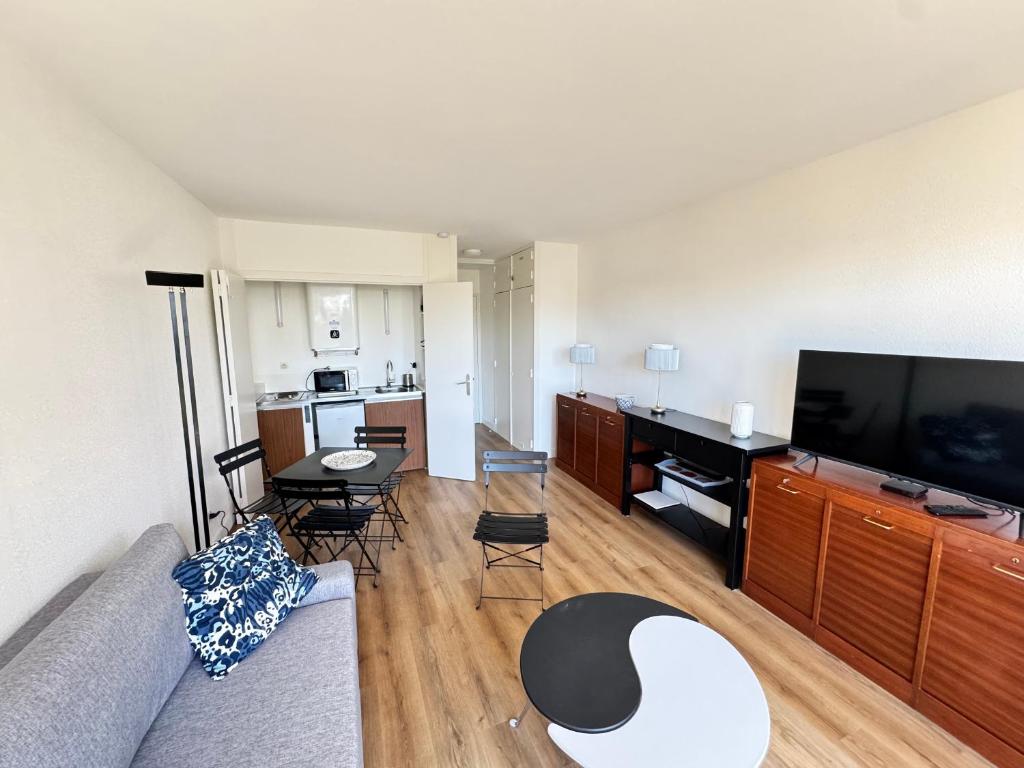un salon avec un canapé et une télévision à écran plat dans l'établissement Studio rénové avec grand balcon, centre-ville, proche plage - FR-1-712-83, à Villers-sur-Mer