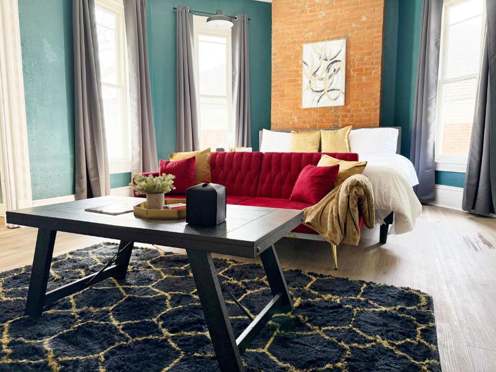 a living room with a red couch and a table at Chandler Studio Apartments in Evansville