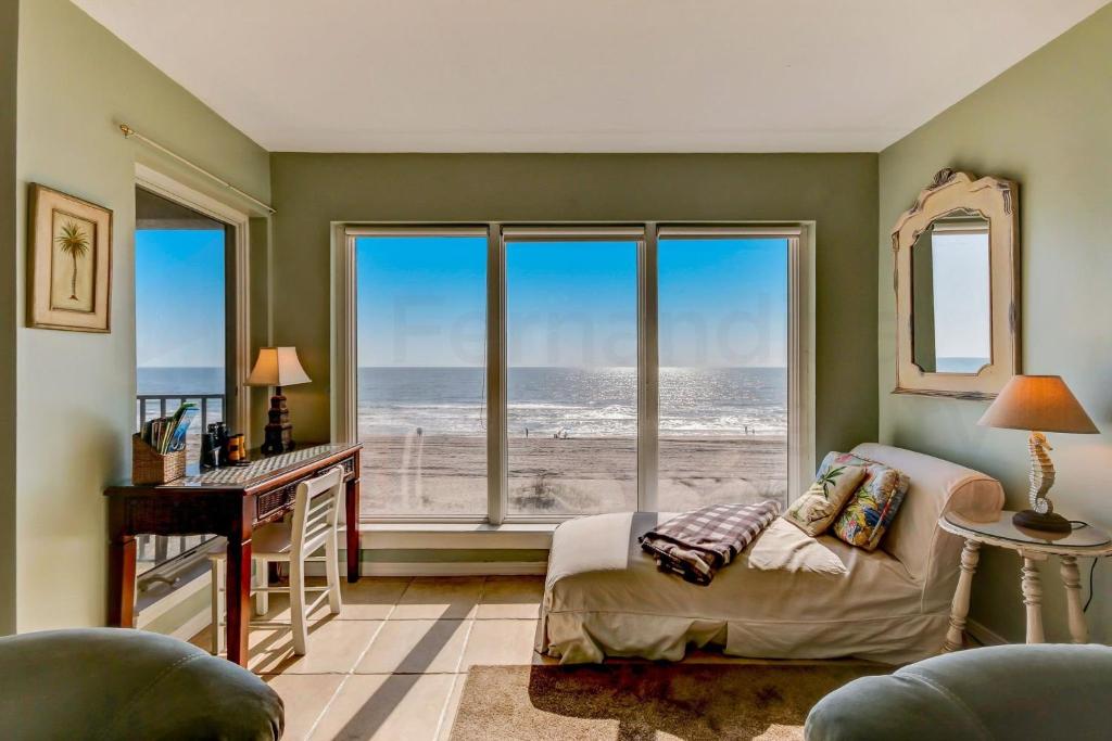 a bedroom with a bed and a desk and a large window at Oceans Of Amelia - 315 Condo in Fernandina Beach