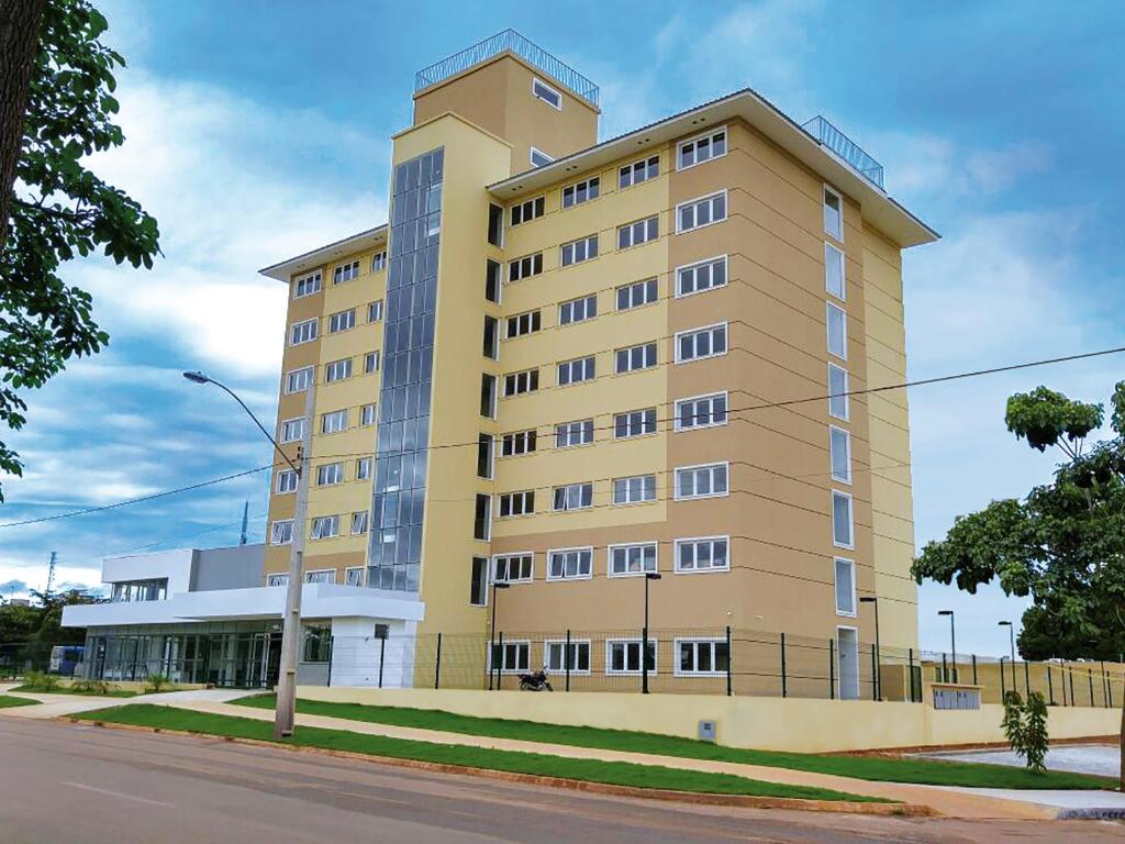 a large yellow building on the side of a street at Hotel 10 Palmas in Palmas