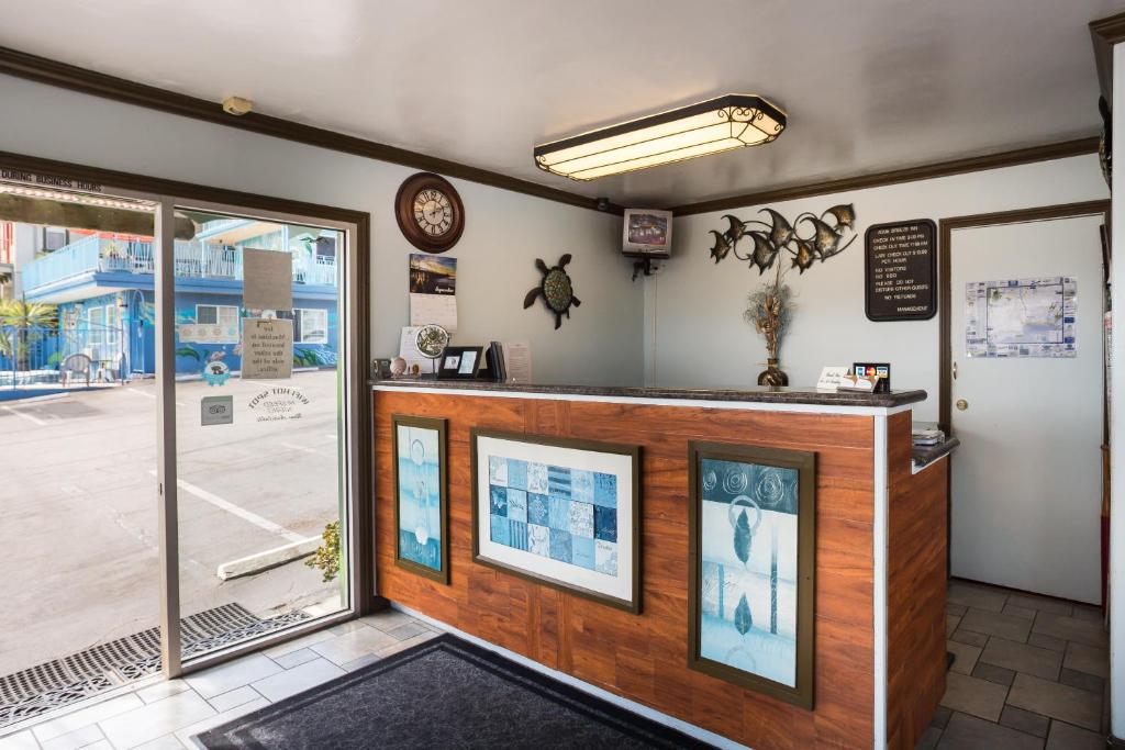 a restaurant with a counter and a clock on the wall at Aqua Breeze Inn in Santa Cruz