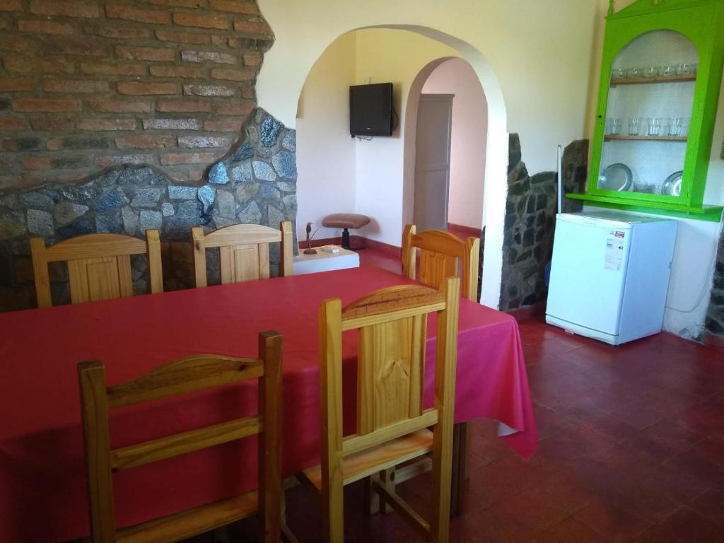 Una cocina con mesa y sillas y un refrigerador. en CasonaLasChilcas, en Tandil