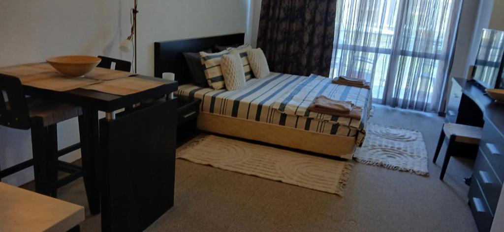 a bedroom with a bed and a desk and a table at Студио за гости на Сарафово in Burgas City