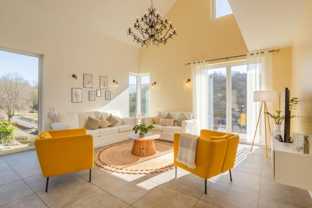 un soggiorno con divano bianco e sedie gialle di Spacious Home Sauna Hot Tub Pool Patio BBQ a Hohenfels-Essingen