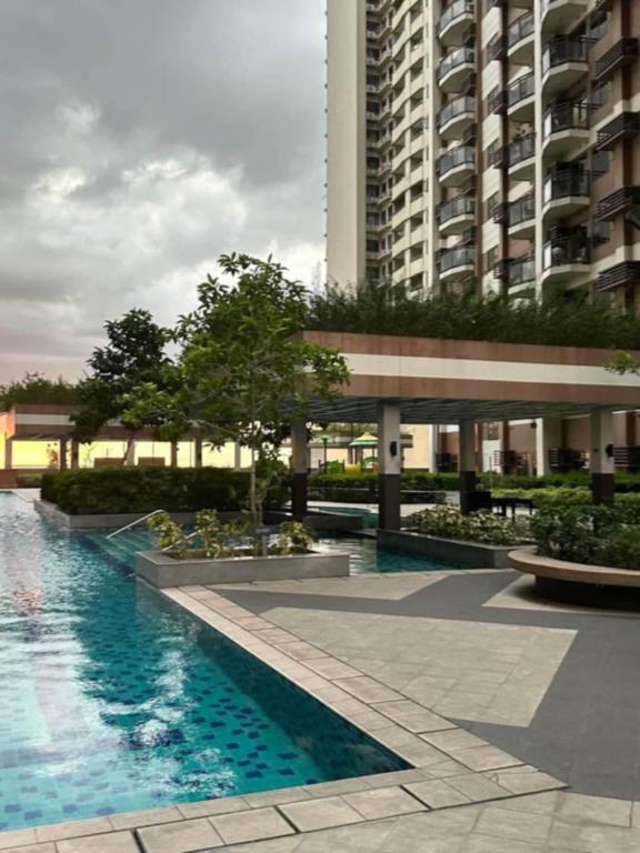 a building with a swimming pool in front of a building at Relaxation Getaway in Manila
