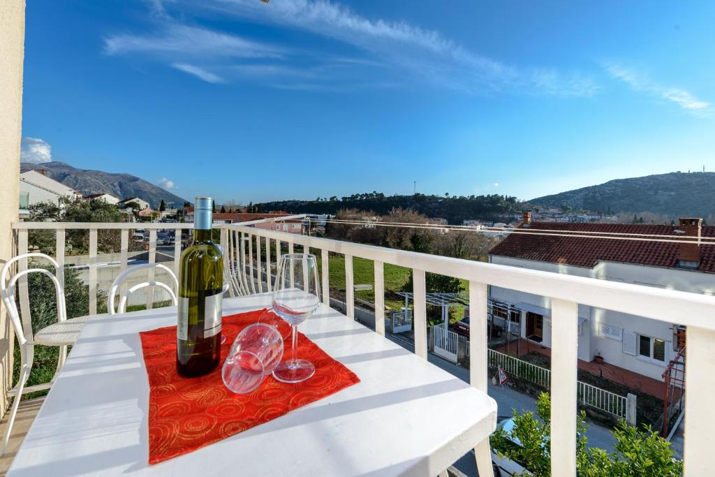 un tavolo con una bottiglia di vino e bicchieri sul balcone di Apartment Fiorenini a Mlini