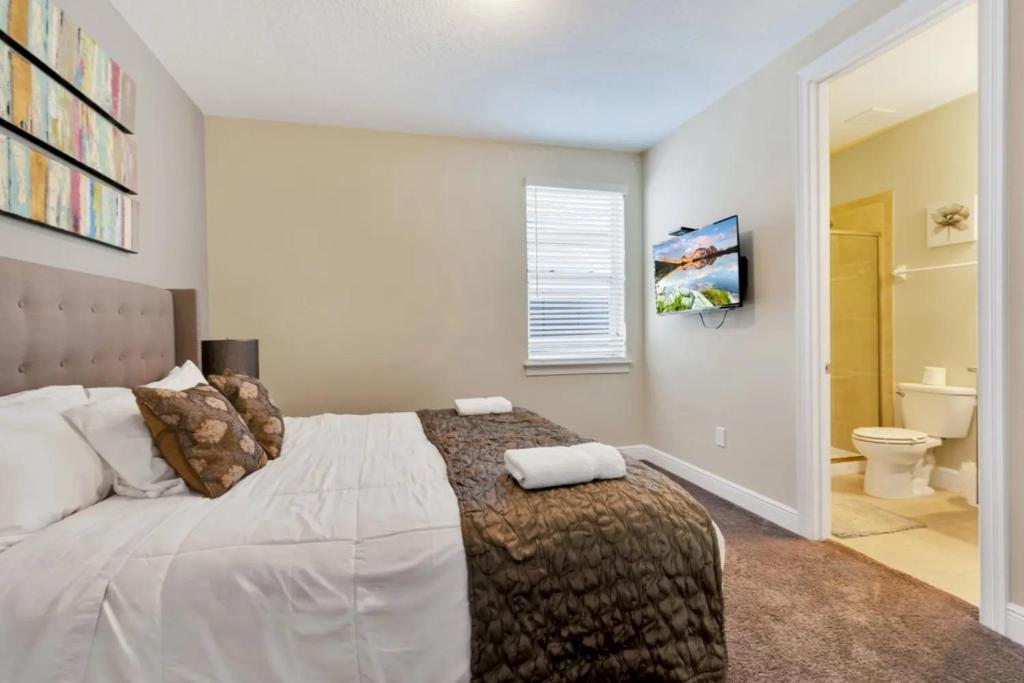a bedroom with a large bed and a bathroom at 491-8-LD-Private Pool with Game and Movie in Orlando