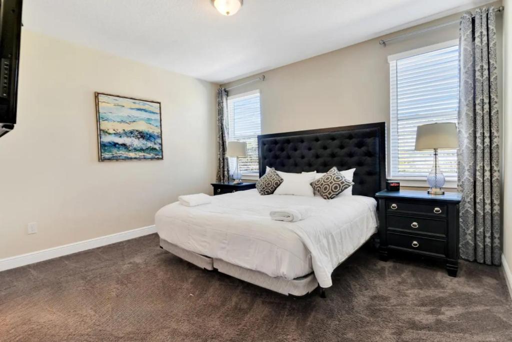 a bedroom with a large bed and two windows at 491-8-LD-Private Pool with Game and Movie in Orlando