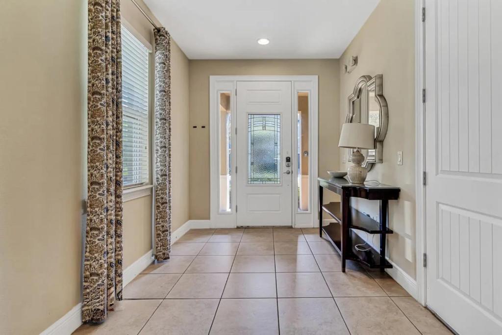 a hallway with a door and a tiled floor at 491-8-LD-Private Pool with Game and Movie in Orlando