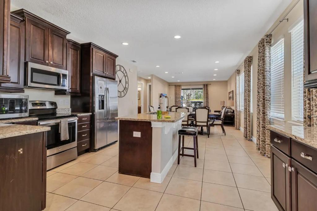 a large kitchen with wooden cabinets and a kitchen island at 491-8-LD-Private Pool with Game and Movie in Orlando