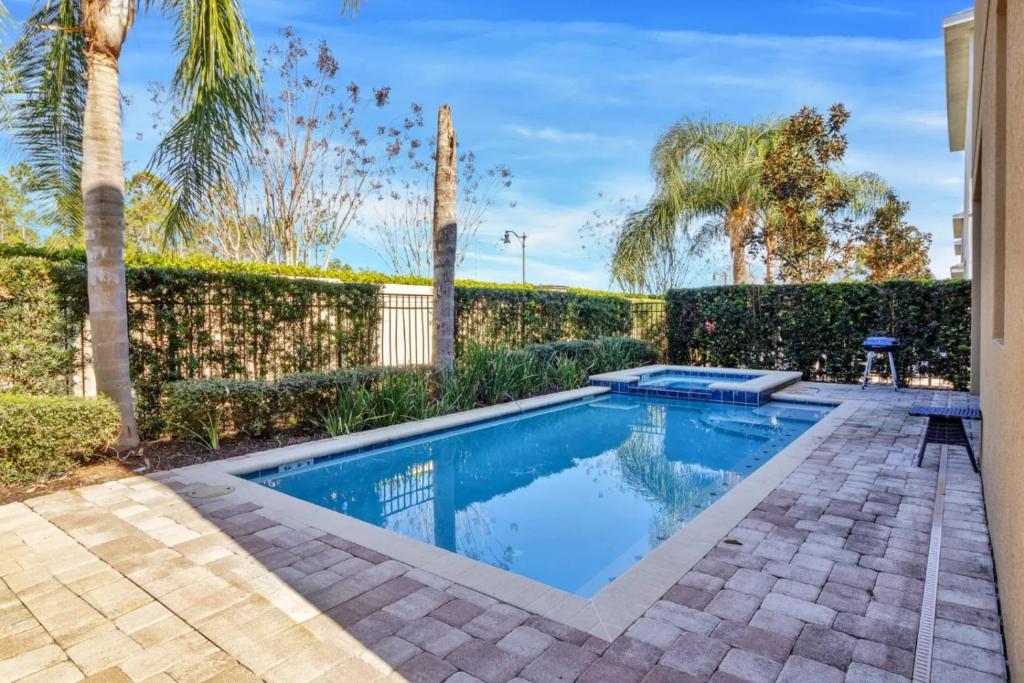 a swimming pool in a backyard with a fence and trees at 491-8-LD-Private Pool with Game and Movie in Orlando