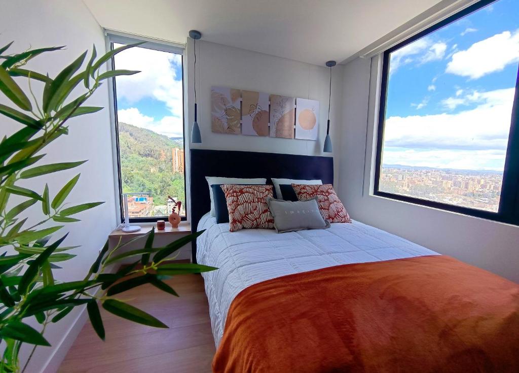 ボゴタにあるAH/ Panorámico Piso11, Balcón, Parking, Bgta Norteのベッドと大きな窓のある寝室