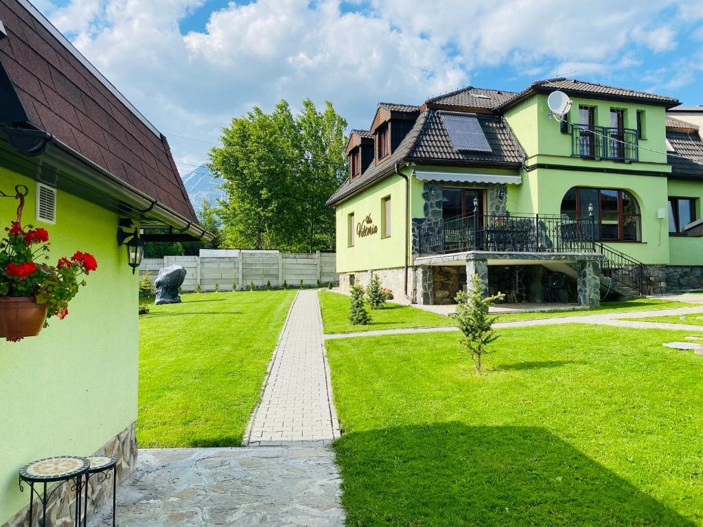 a large house with a grassy yard next to a building at Vila Viktoria in Štôla