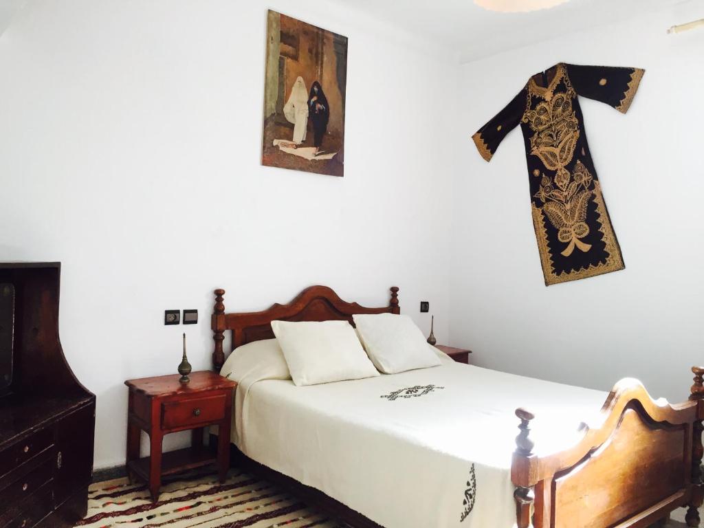- une chambre avec un lit et une traverse suspendue au mur dans l'établissement Chez Fouzia, à Essaouira