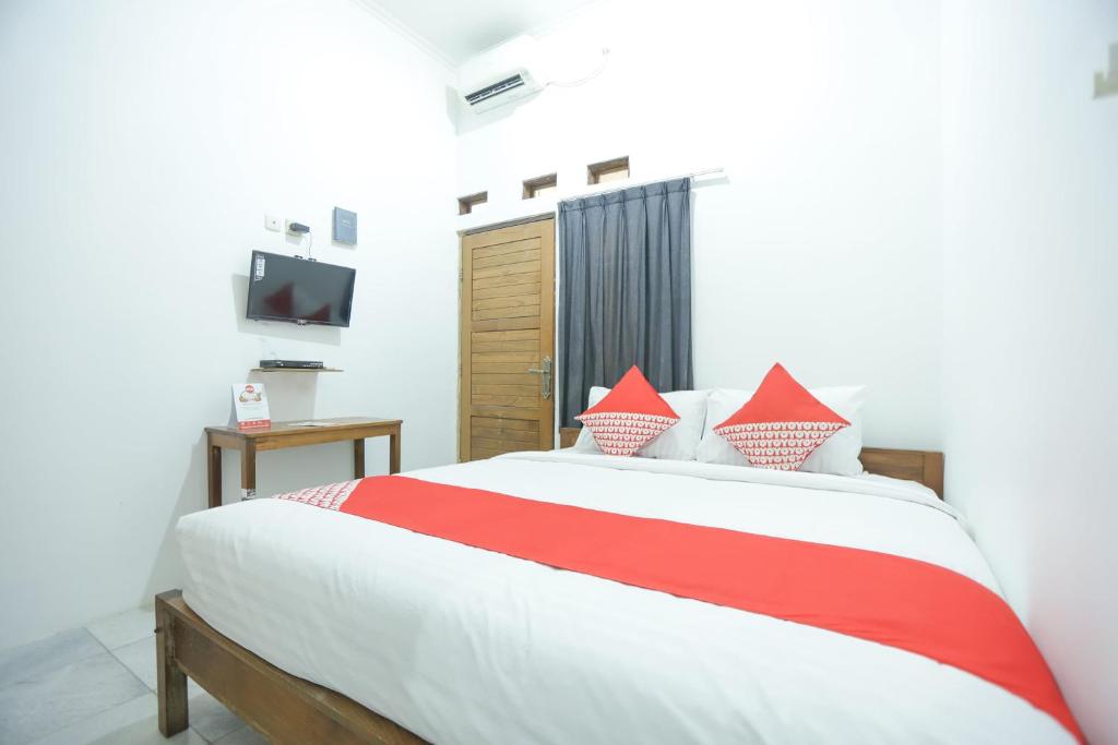 a bedroom with a red and white bed and a television at Hotel O near Bundaran HI formerly Harmoni Residence in Jakarta