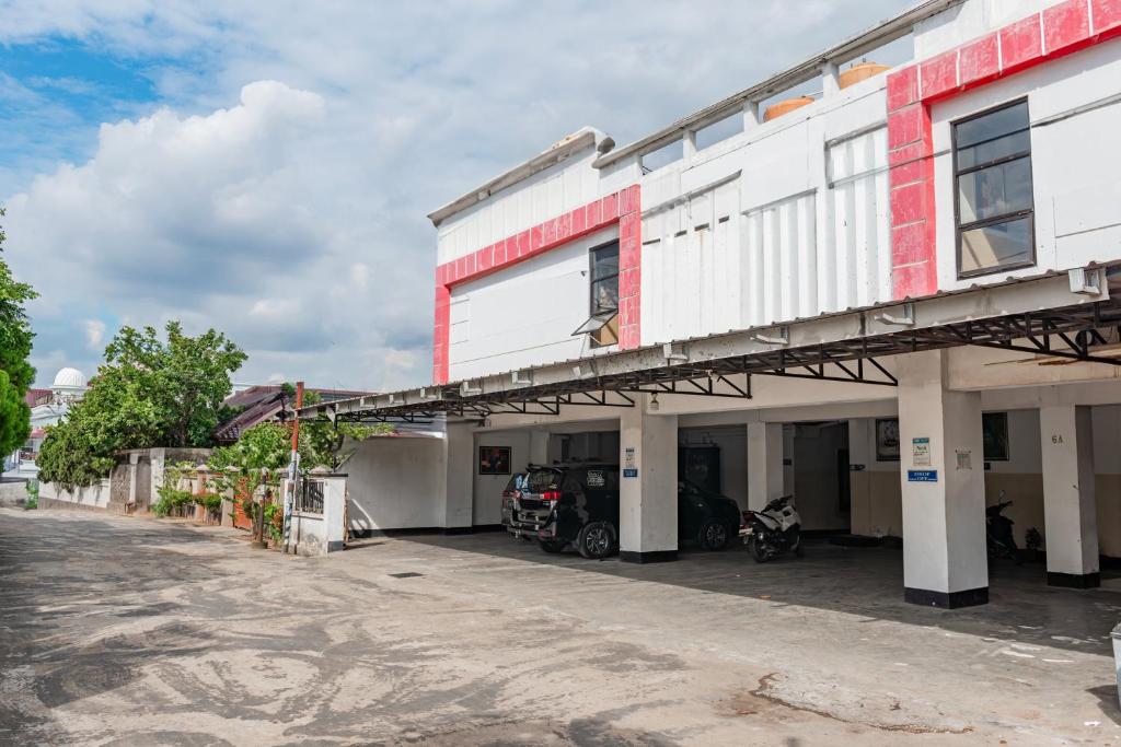 a building with a car parked outside of it at Hotel O Ilir Barar I Near Rumah Sakit Islam Siti Khadijah Formerly Maleo Hotel in Palembang