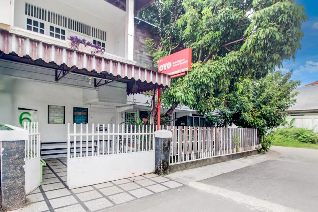 a white fence in front of a building at Hotel O Jalan Jenderal Sudirman Near Imam Bonjol Square Formerly Nelvi Guest House in Padang