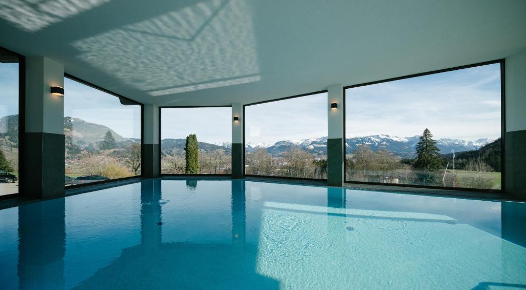 a swimming pool with a view of mountains at Panoramahotel Kühbergalp in Gunzesried