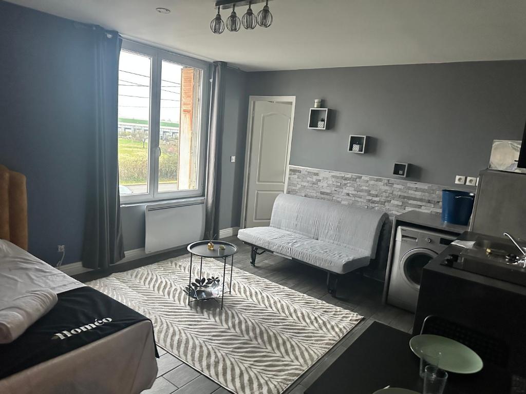 - un salon avec un lit, un canapé et un tapis dans l'établissement Le Cosy De La Gare 7, à Nazelles-Négron