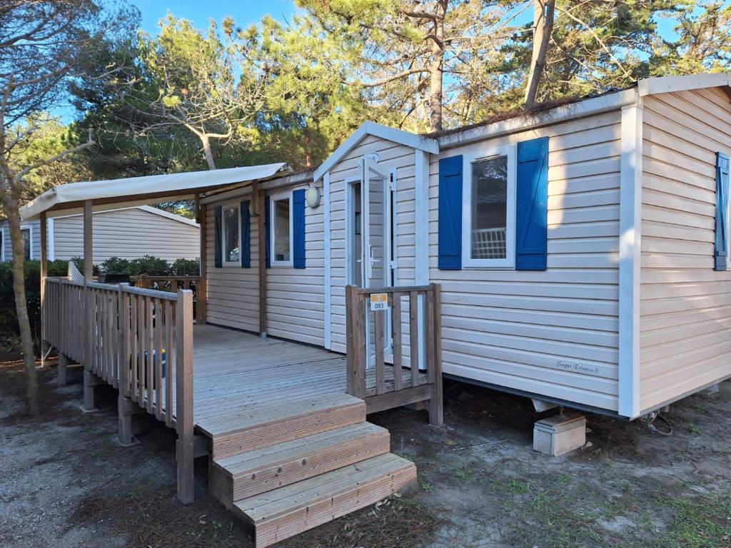 une petite maison avec un porche et une terrasse dans l'établissement Mobil home 6 personnes, au Barcarès