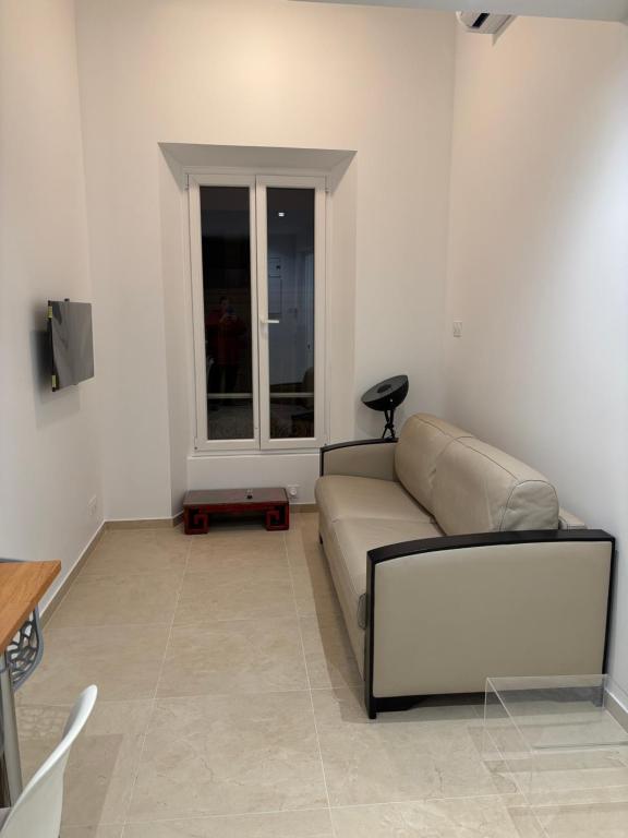 un salon avec un canapé et une fenêtre dans l'établissement STA4 Le Suquet, Proche Mer et Palais des Congrès, à Cannes