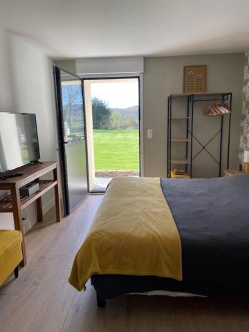 a bedroom with a bed and a sliding glass door at La Martinière in Saint-Martin-sur-Oust