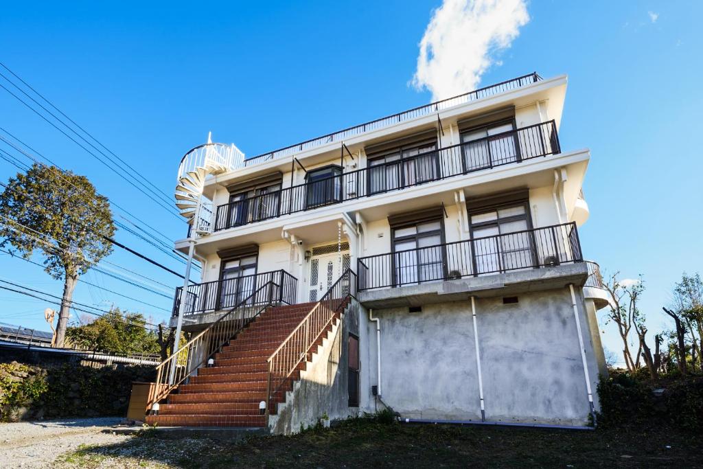an old white building with stairs and a balcony at 伊豆の情景 Izu Nostalgia in Ito
