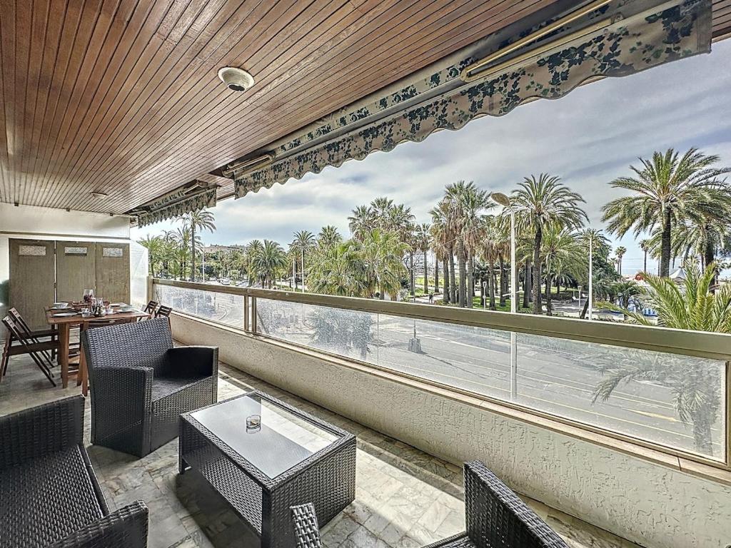 d'un balcon avec vue sur l'océan et les palmiers. dans l'établissement 61m2 - terrasse vue mer, croisette, à Cannes