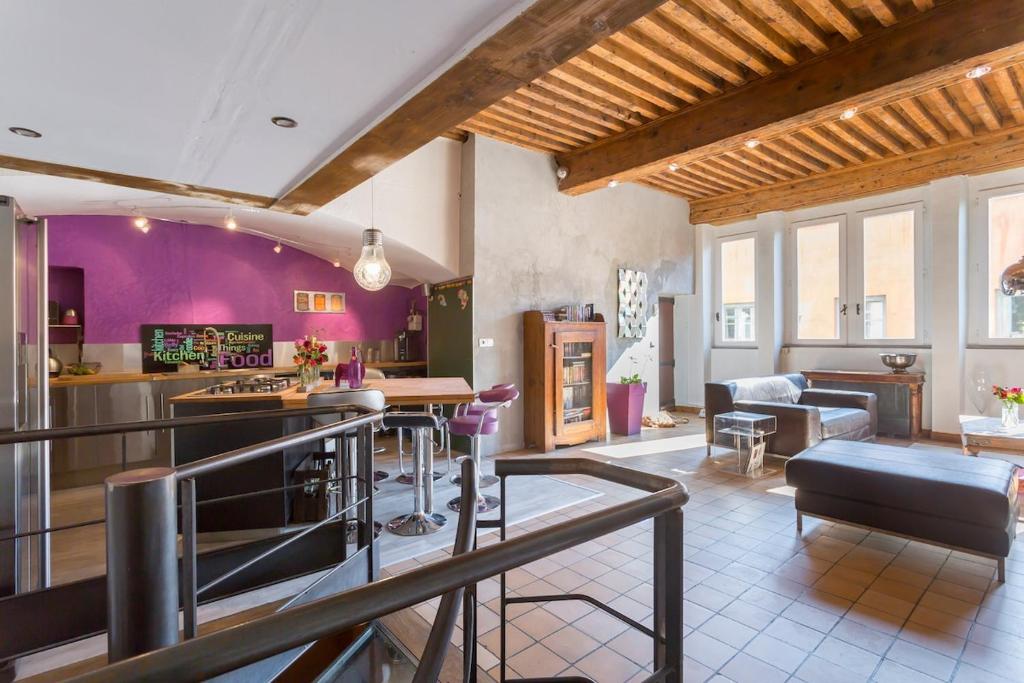 a kitchen and living room with purple walls at Le Duplex de Fourvière in Lyon
