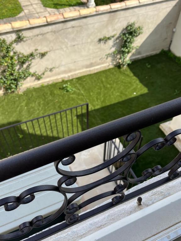 un banc sur un balcon avec vue sur la pelouse dans l'établissement Latour des Sens, à Pont-Saint-Esprit