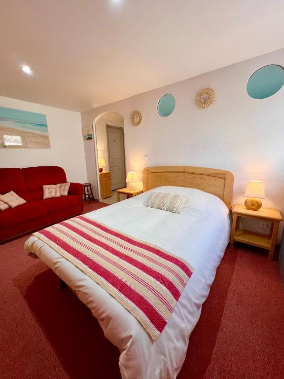 - une chambre avec un grand lit et un canapé rouge dans l'établissement Le Neptune, Calme, Centre-ville, à Royan