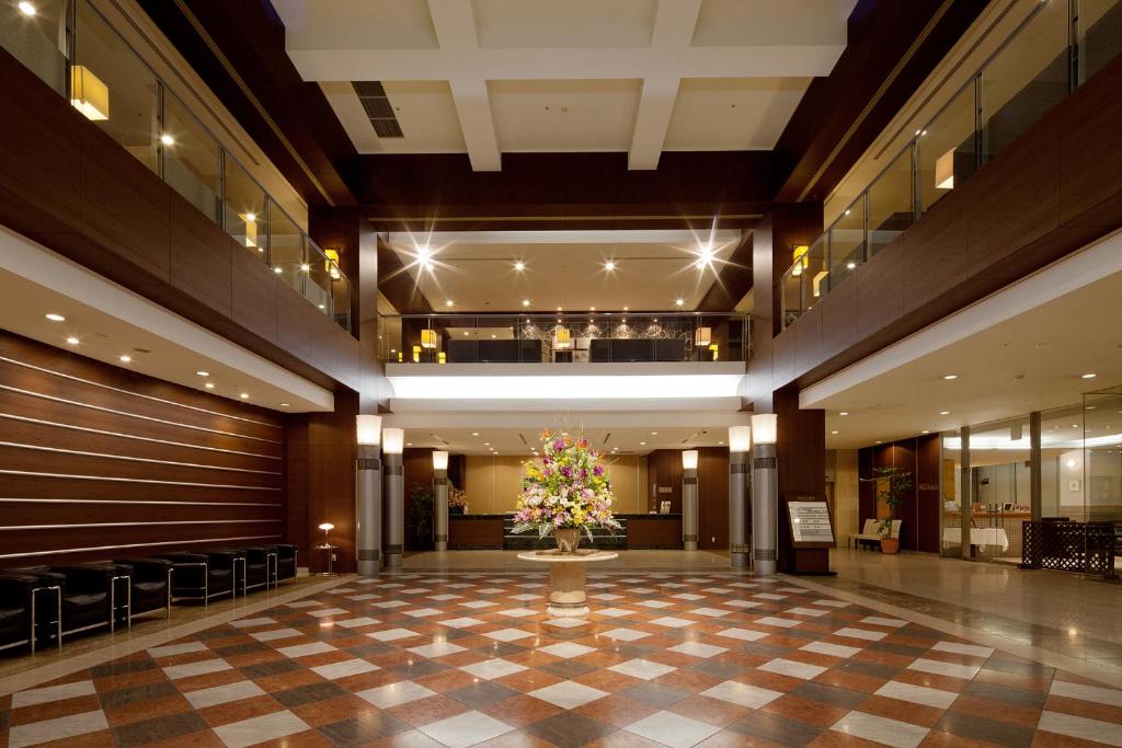 a large lobby with a vase of flowers in the middle at Ueda Tokyu REI Hotel in Ueda