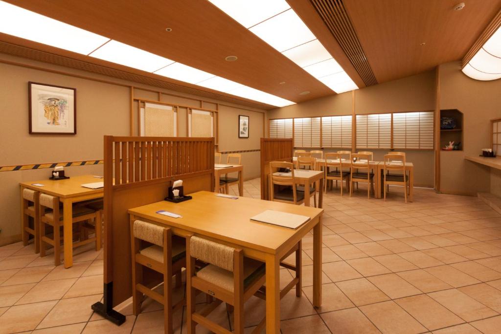 a dining room with wooden tables and chairs at Ueda Tokyu REI Hotel in Ueda
