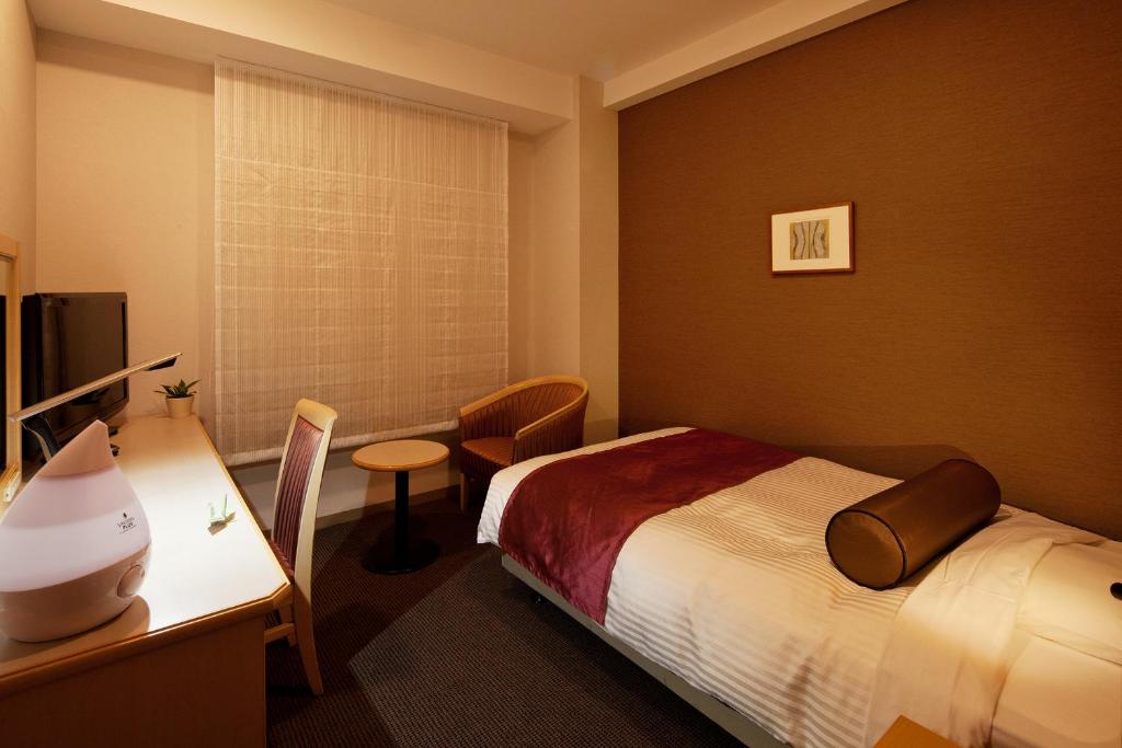 a hotel room with a bed and a desk at Ueda Tokyu REI Hotel in Ueda