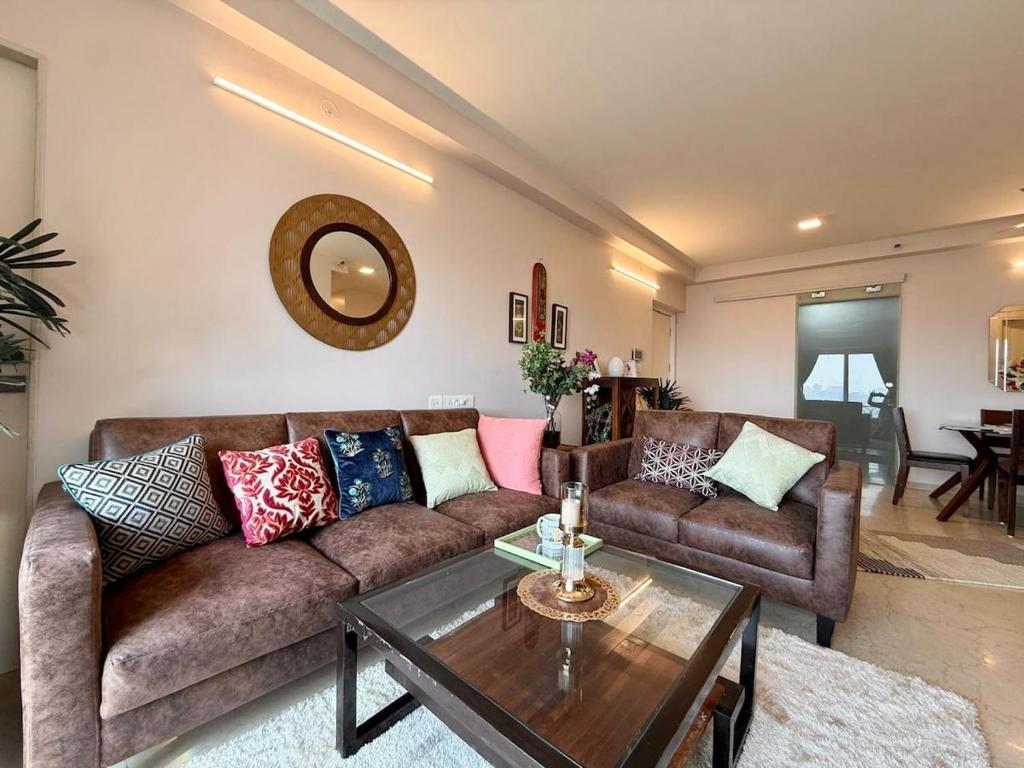 a living room with a couch and a table at 5 Star Luxury Pool, Gym Near Airport BKC in Mumbai