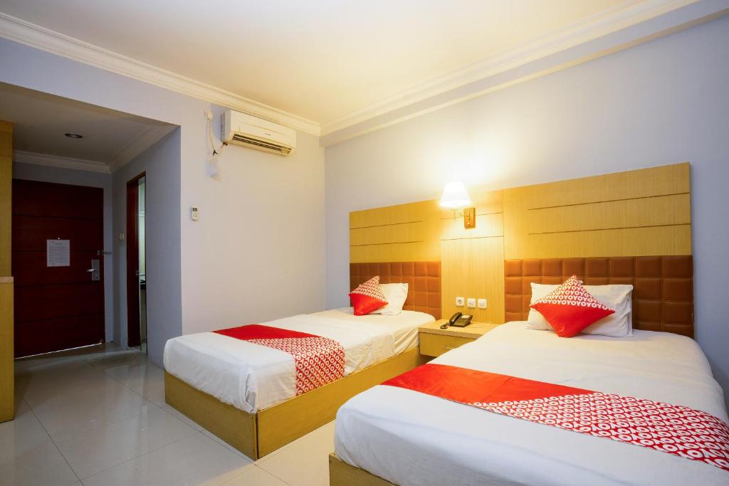 Postel nebo postele na pokoji v ubytování Super OYO 1088 Hotel Mega Sentosa