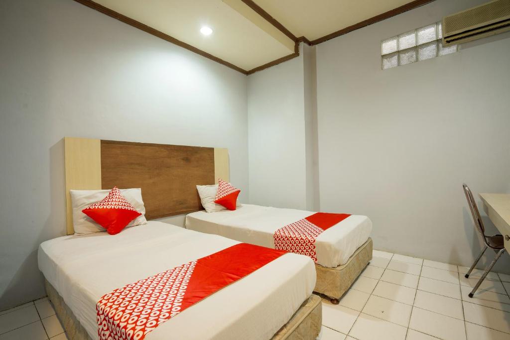 Postel nebo postele na pokoji v ubytování Super OYO 1088 Hotel Mega Sentosa