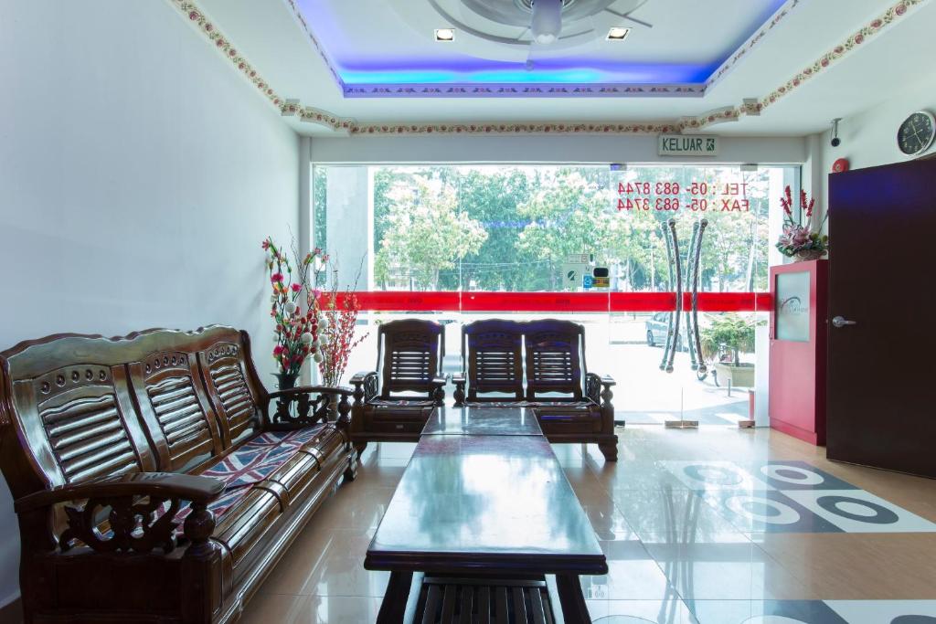 sala de estar con sofás y mesa frente a una ventana en Valley View Hotel, en Lumut