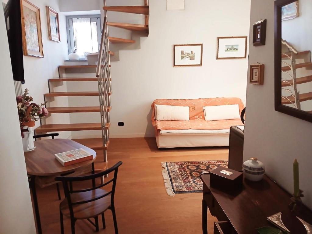 sala de estar con escalera, mesa y sofá en A room in the 'borgo', en Dogliani