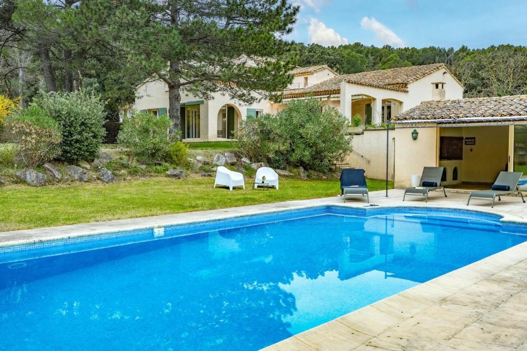 une piscine devant une maison dans l'établissement Près d'Avignon élégante villa avec vue, à Pujaut