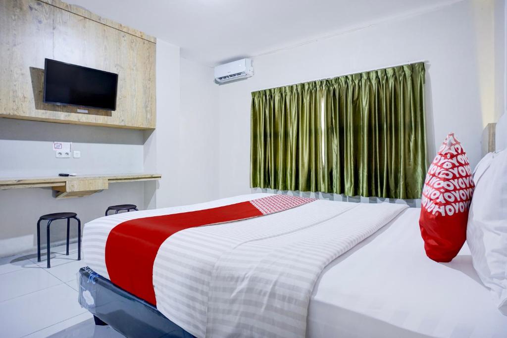 Postel nebo postele na pokoji v ubytování Collection O Gapura Hotel Near Parapat Penatapan Danau Toba