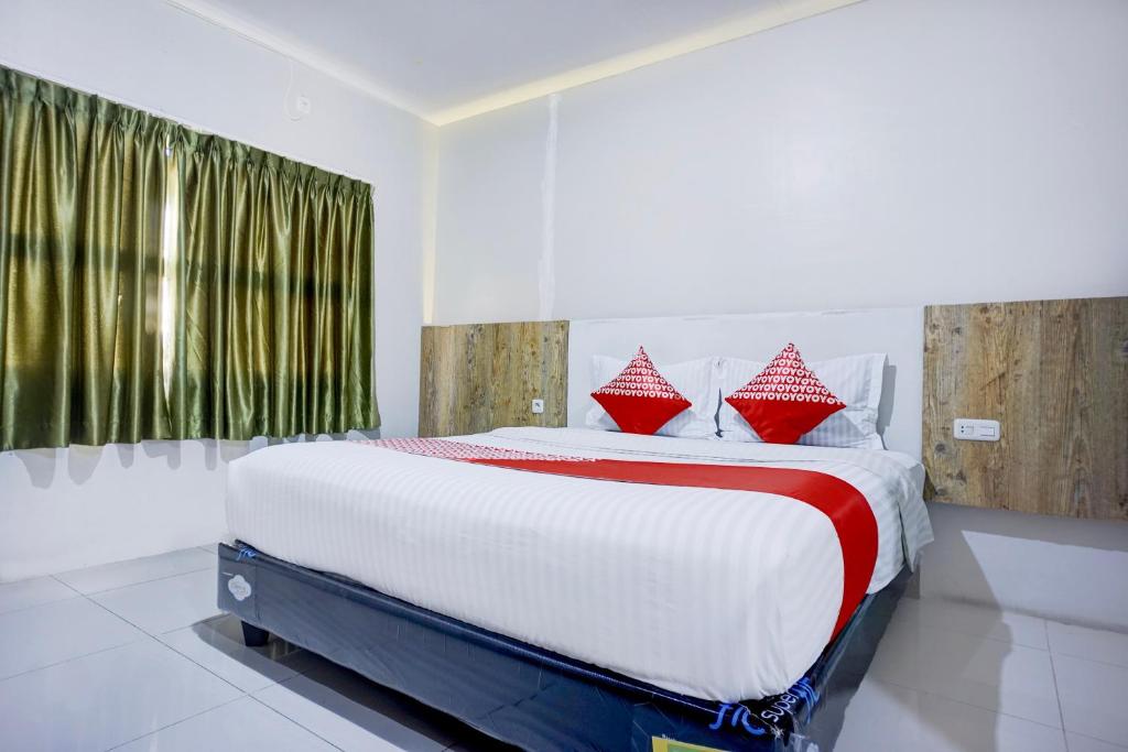 Postel nebo postele na pokoji v ubytování Collection O Gapura Hotel Near Parapat Penatapan Danau Toba