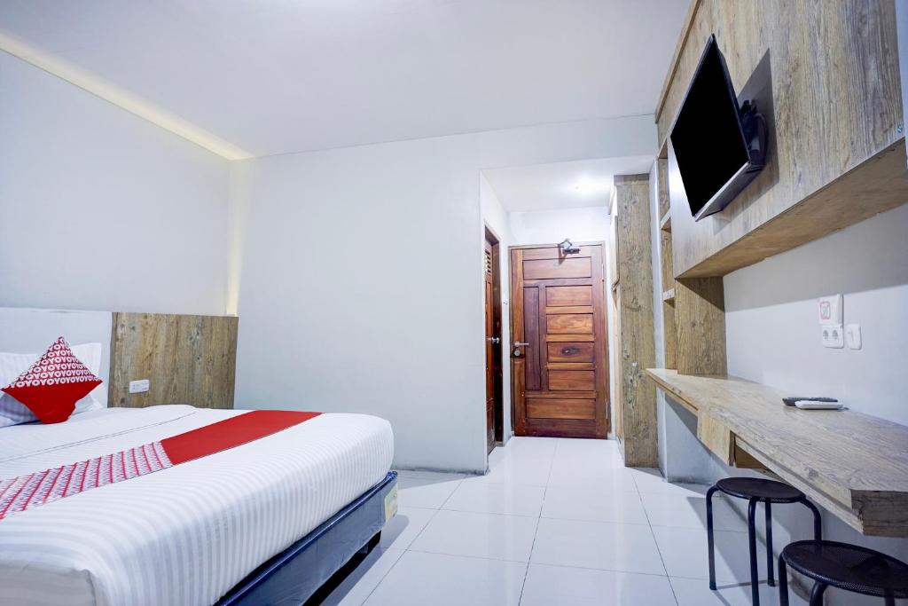 Postel nebo postele na pokoji v ubytování Collection O Gapura Hotel Near Parapat Penatapan Danau Toba