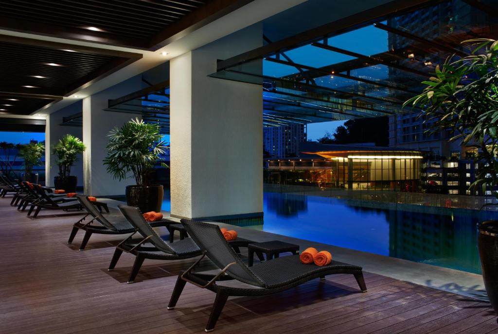 A rooftop-style pool terrace with loungers at night.