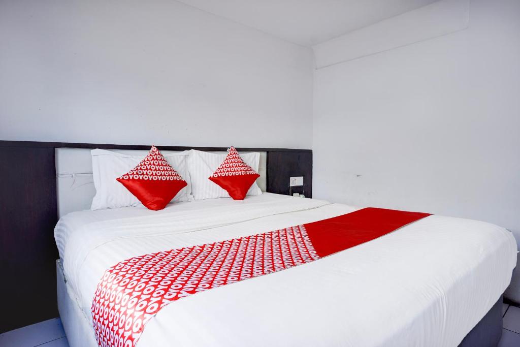Postel nebo postele na pokoji v ubytování Collection O Gapura Hotel Near Parapat Penatapan Danau Toba
