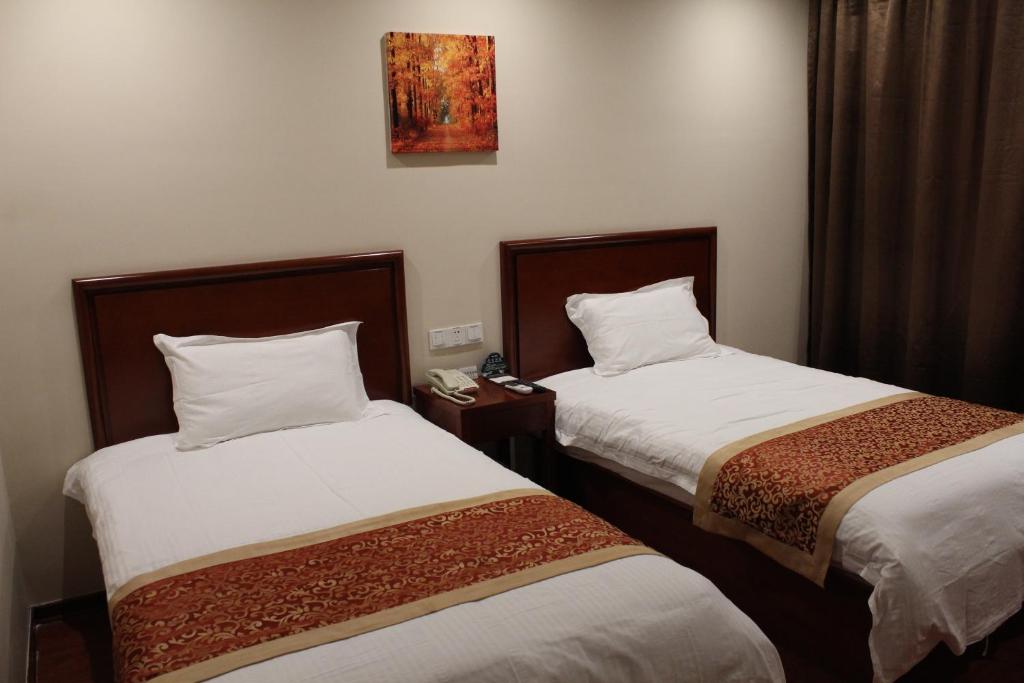 a hotel room with two beds and a phone at GreenTree Inn Zhejiang Ningbo Dongqian Lake Yinxian Avenue North Mozhi Road Business Hotel in Ningbo