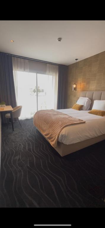 una camera con un grande letto e una grande finestra di Hôtel égide a Espalion
