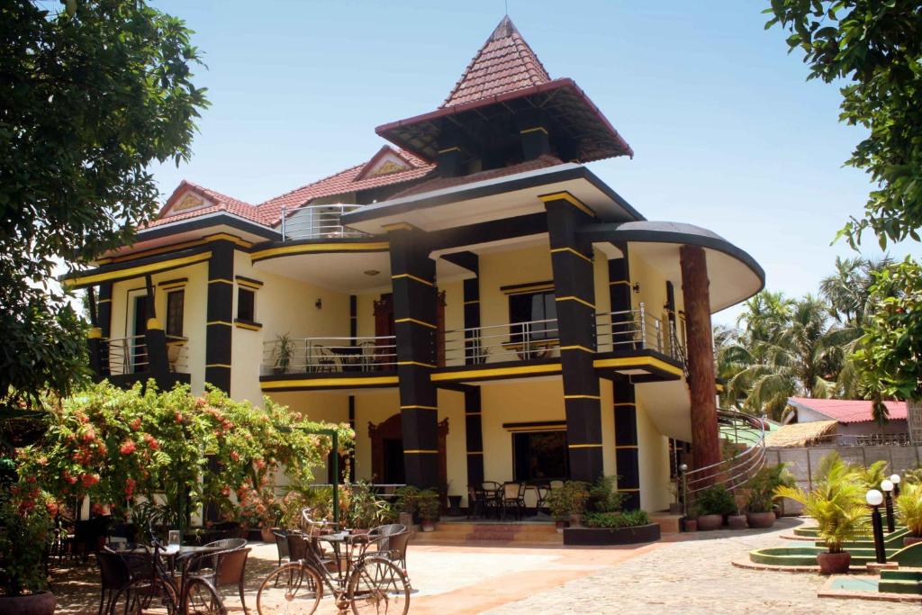 a large building with tables and chairs in front of it at The Magic Sponge in Kampot