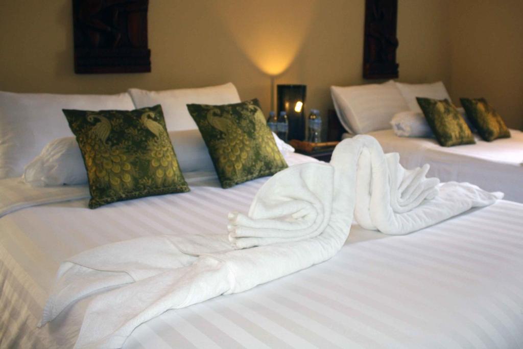 two beds with white towels on top of them at The Magic Sponge in Kampot