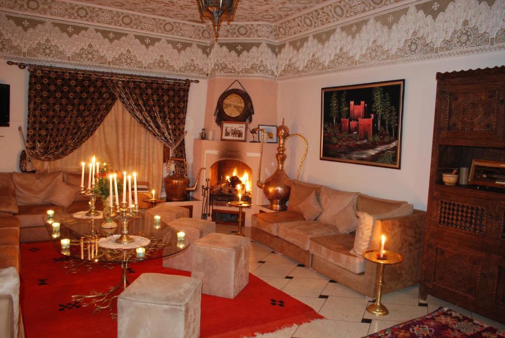 a living room with a couch and a fireplace at Riad Villa Midelt in Midelt